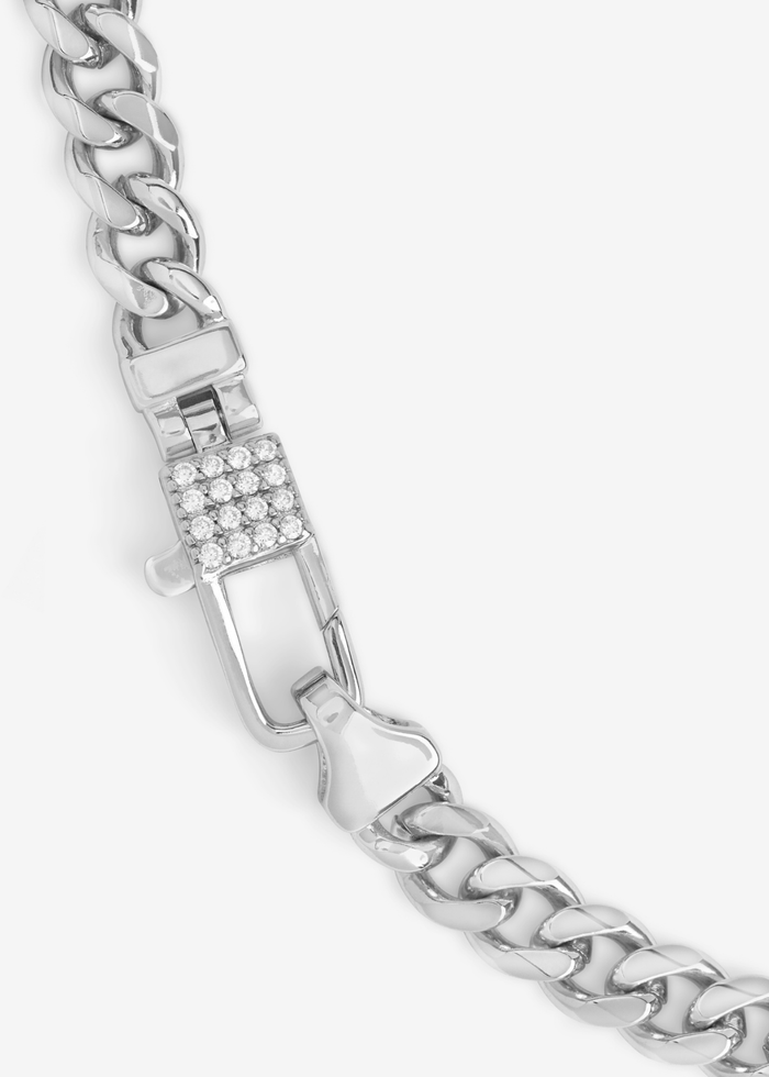 Close up of a silver chain necklace with a lock clasp and pave accents on a white background