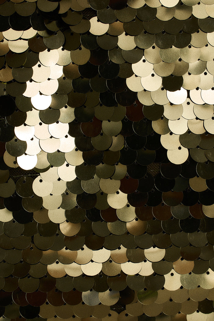 Extreme close-up of overlapping olive paillette sequins on the Miramar mini skirt.