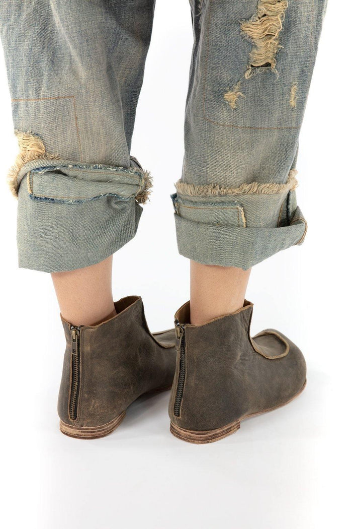 Distressed denim pants with frayed cuffs and vintage artisan leather boots by Magnolia Pearl
