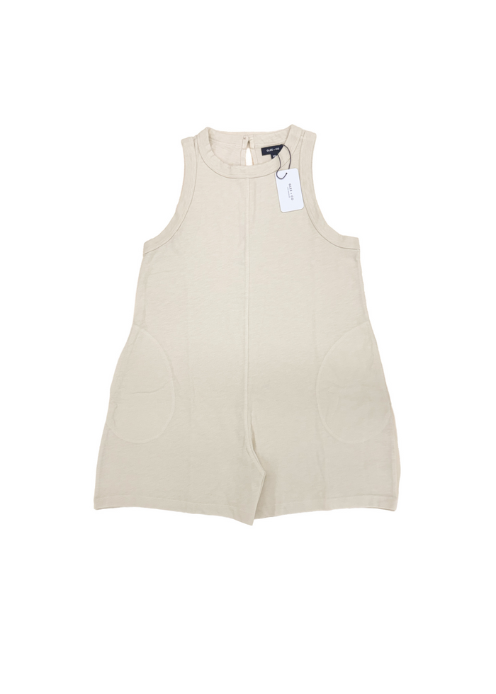 A sleeveless cream-colored romper with two side pockets, shown flat on a white background with a hangtag attached.
