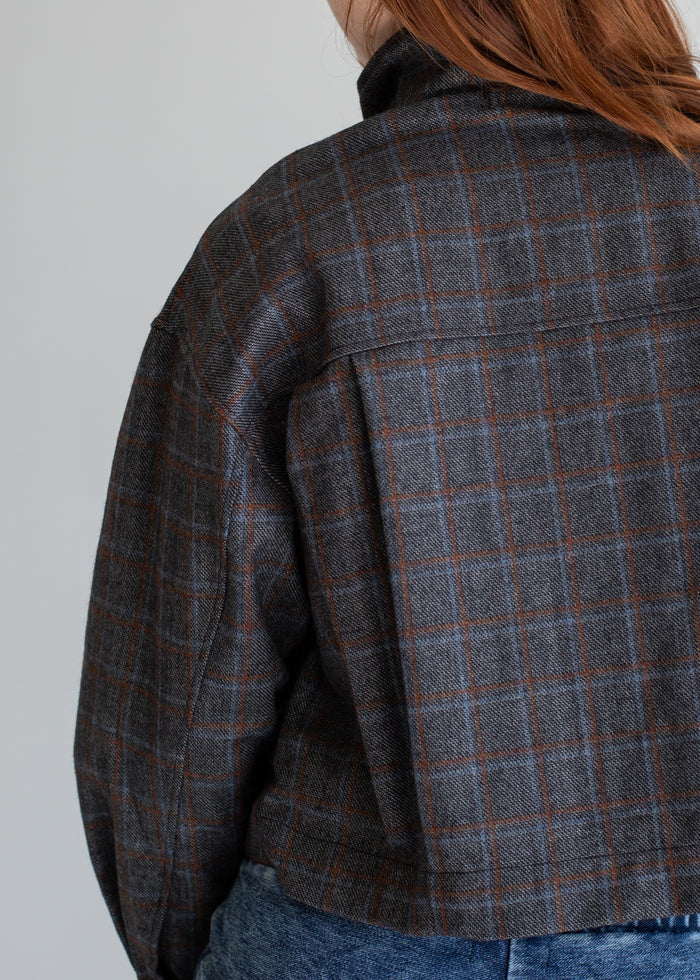 Plaid jacket worn by a person on a plain background