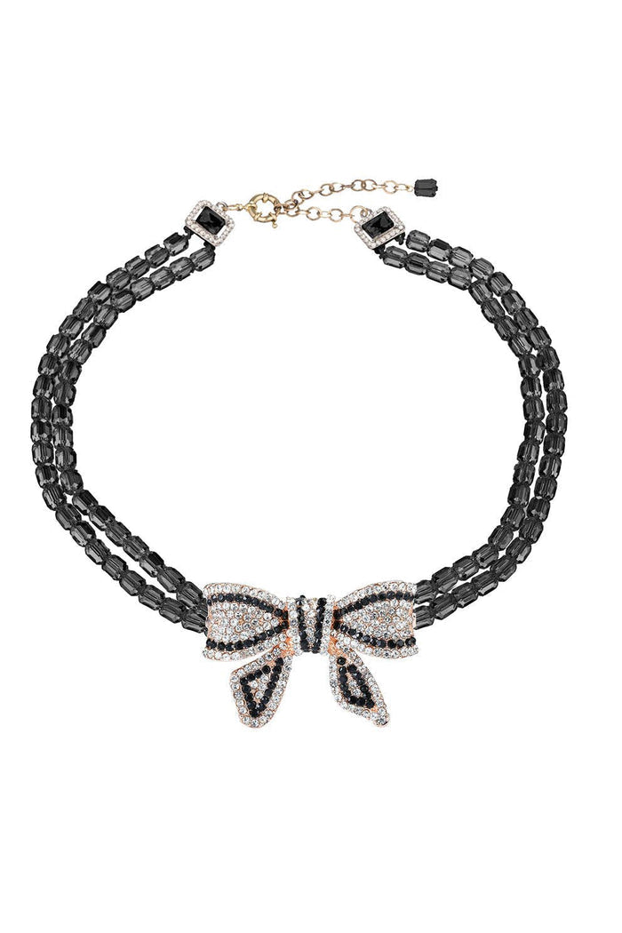 Black double-strand beaded necklace with a large cubic zirconia bow pendant and adjustable chain extender.