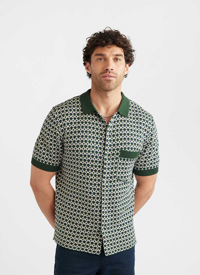 A model wears the Percival Casa Piccante Shirt, a green jacquard knit with solid green collar, pocket, and sleeve cuffs.
