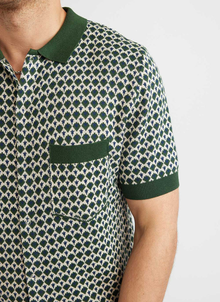 Close up of the Percival Casa Piccante knitted shirt, showing the green, white and blue jacquard pattern and pocket.