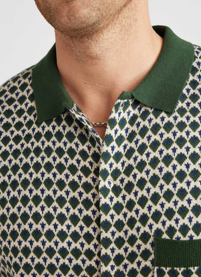 Close up of the Percival Casa Piccante knitted shirt in green jacquard, showing the collar, snap buttons and pattern detail.