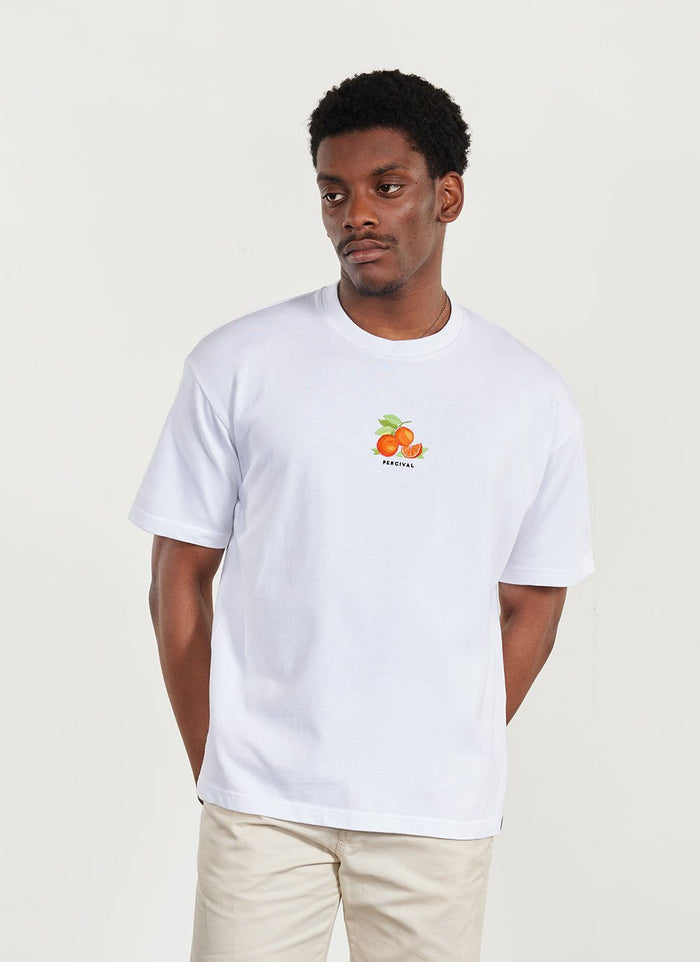 A model wears the white Percival Citrus oversized t-shirt, which has a small embroidered orange graphic on the chest.