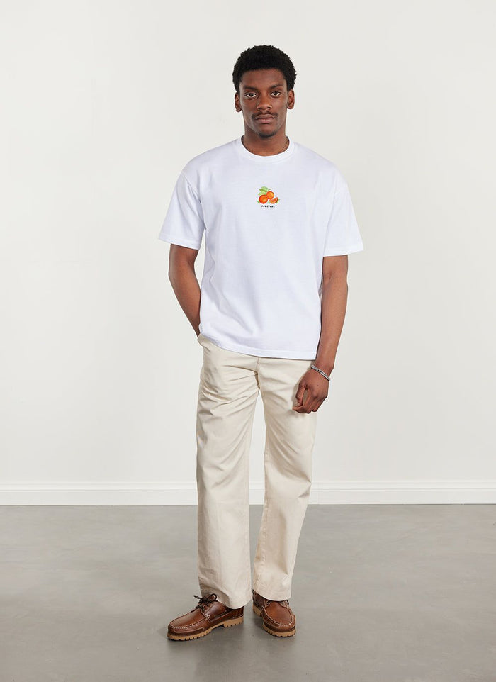 A model wears the white Percival Citrus oversized t-shirt with cream trousers and brown leather shoes.