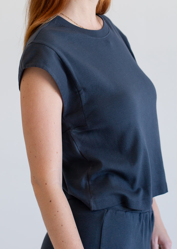 Woman wearing a navy blue top against a light background