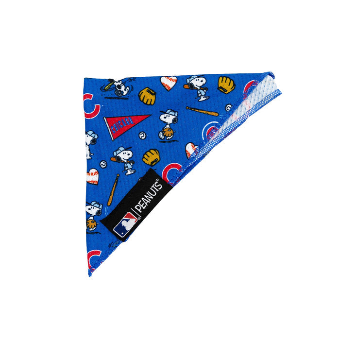 The Sassy Woof Dog Bandana - MLB™ x Peanuts™ Chicago Cubs™ is a blue triangle bandana featuring Snoopy baseball, Peanuts characters, bats, gloves, balls, Cubs logos, and an official MLB Peanuts Chicago Cubs label on the front.