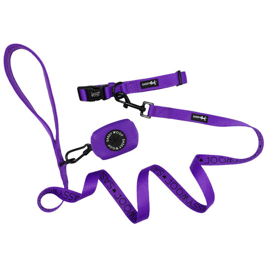 The Dog Collar Three Piece Bundle - Neon Purple by Sassy Woof includes a vibrant neon purple dog leash, collar, and small pouch. The neon leash features the repeated text “SASSY WOOF,” while both the collar and pouch also showcase the Sassy Woof brand name, making this bundle the perfect set of coordinating dog accessories.