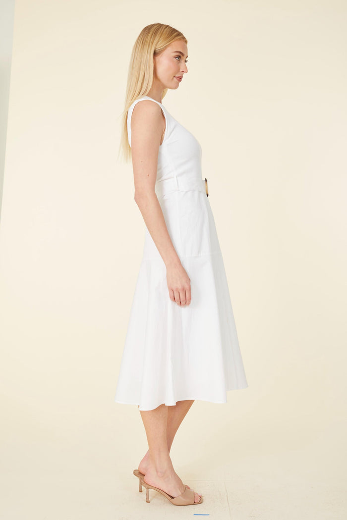 Model in a white dress with a tortoise shell belt buckle