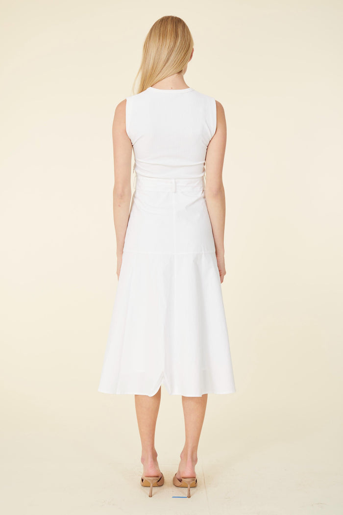 Model in a white dress with a tortoise shell belt buckle