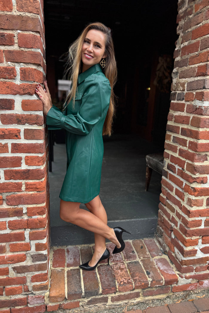 Woman in a green dress standing in a brick doorway