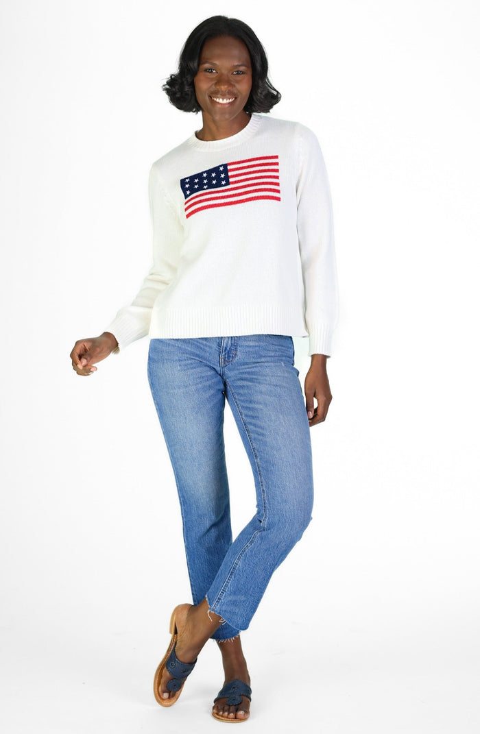 Woman In a white sweater with an American flag and jeans