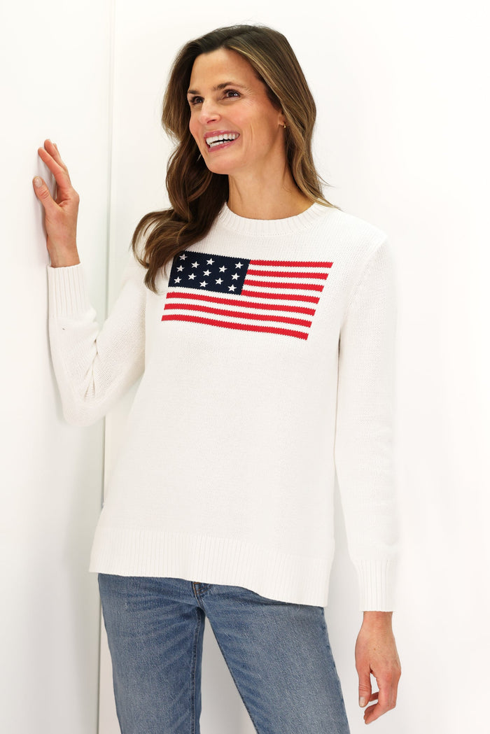 Woman In a white sweater with an American flag and jeans