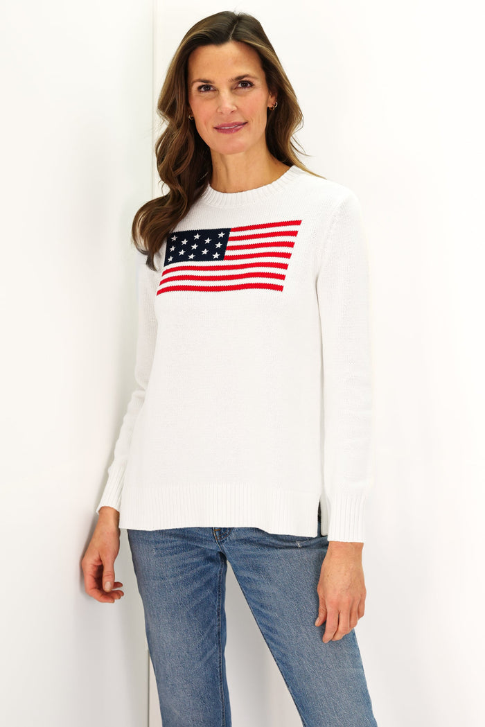 Woman In a white sweater with an American flag and jeans