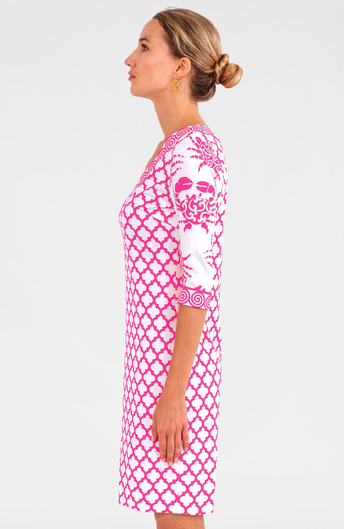 Blonde woman facing sideways wearing pink and white geometric print 3/4 sleeve v-neck dress with contrast crab print on sleeves