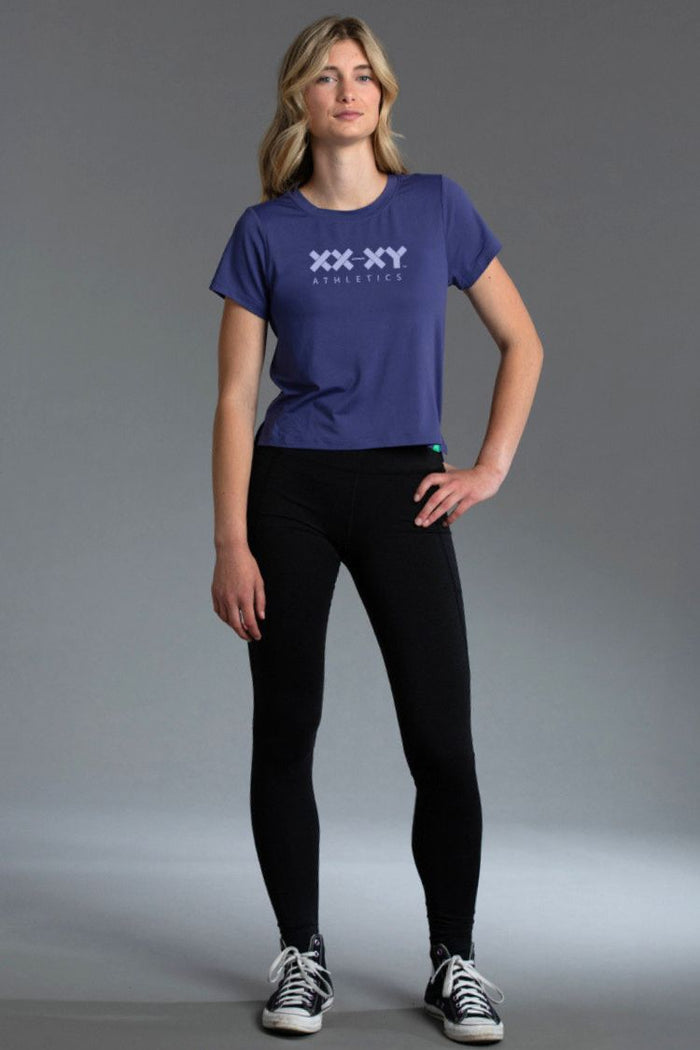Woman wearing Blue t-shirt with a logo and black leggings || Indigo
