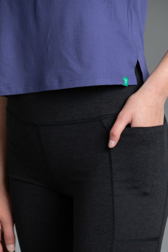 Person wearing blue T-shirt with black pants with a visible brand logo || indigo