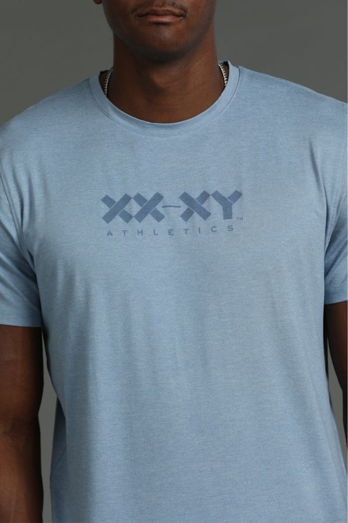 Person wearing a light blue t-shirt with 'XY Athletics' logo || Cerulean Blue Heather