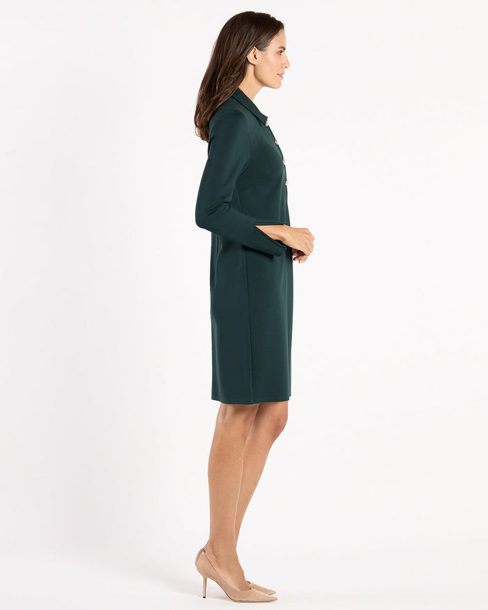Side view of model in the Jude Connally Midge Dress - Pine/Gold, a dark green dress with gold buttons and a shirt collar