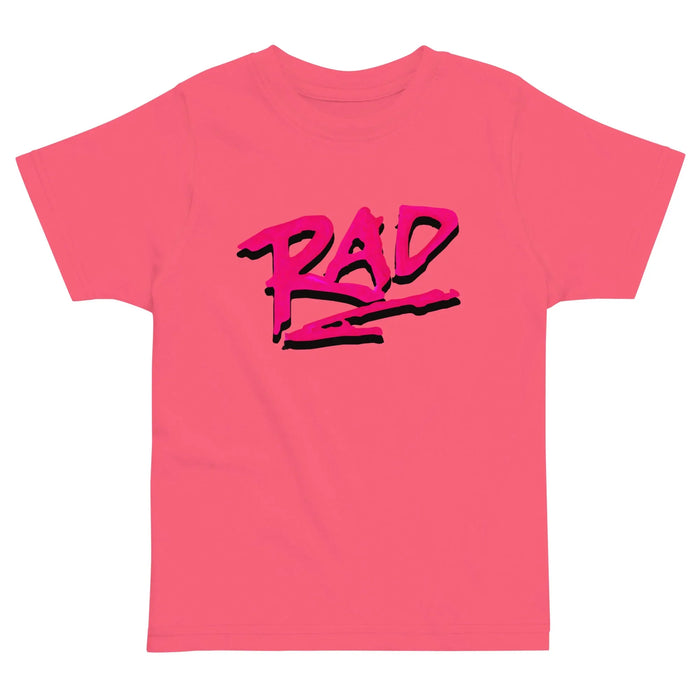 Just a Rad Kid's Tee - The jagged, wet-marker typography in electric magenta (#E03C95) with muted slate grey shadow (#4F4F4F), specifically stylized with a swift horizontal underscore in magenta (#E03C95).