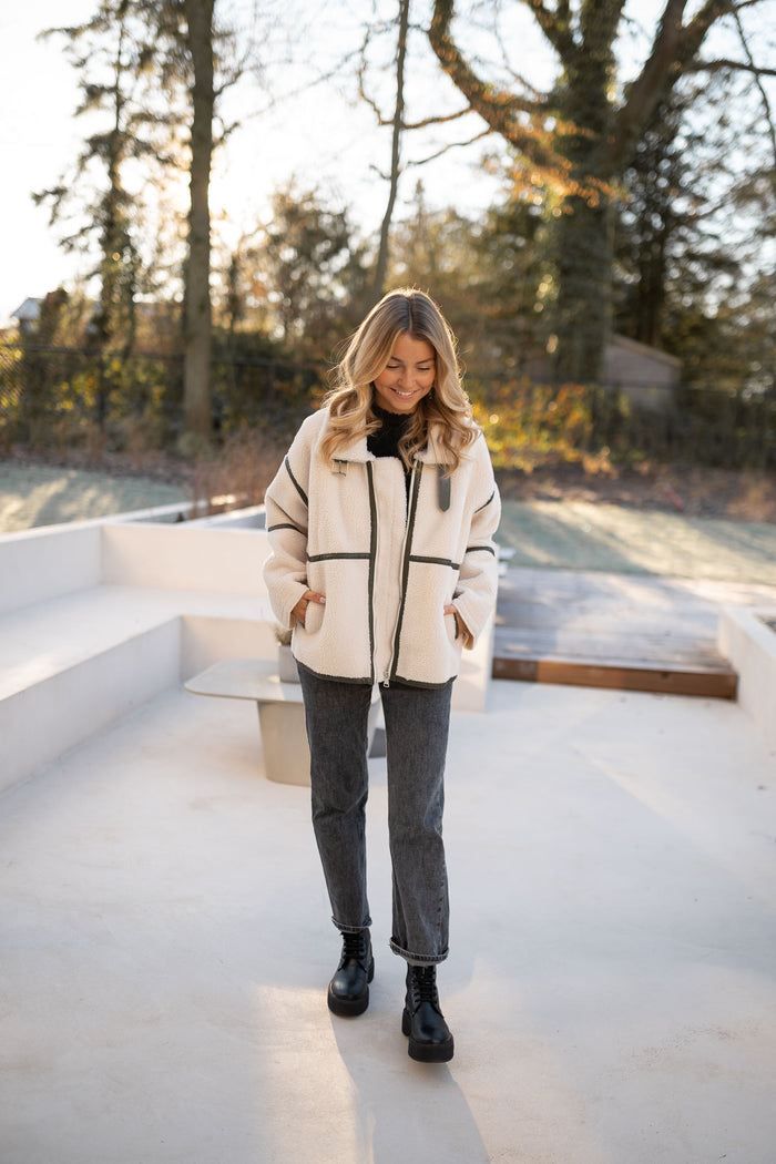 Detail of khaki trim on cream shearling jacket