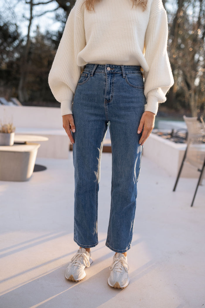Straight-leg medium-blue jeans styled with sneakers