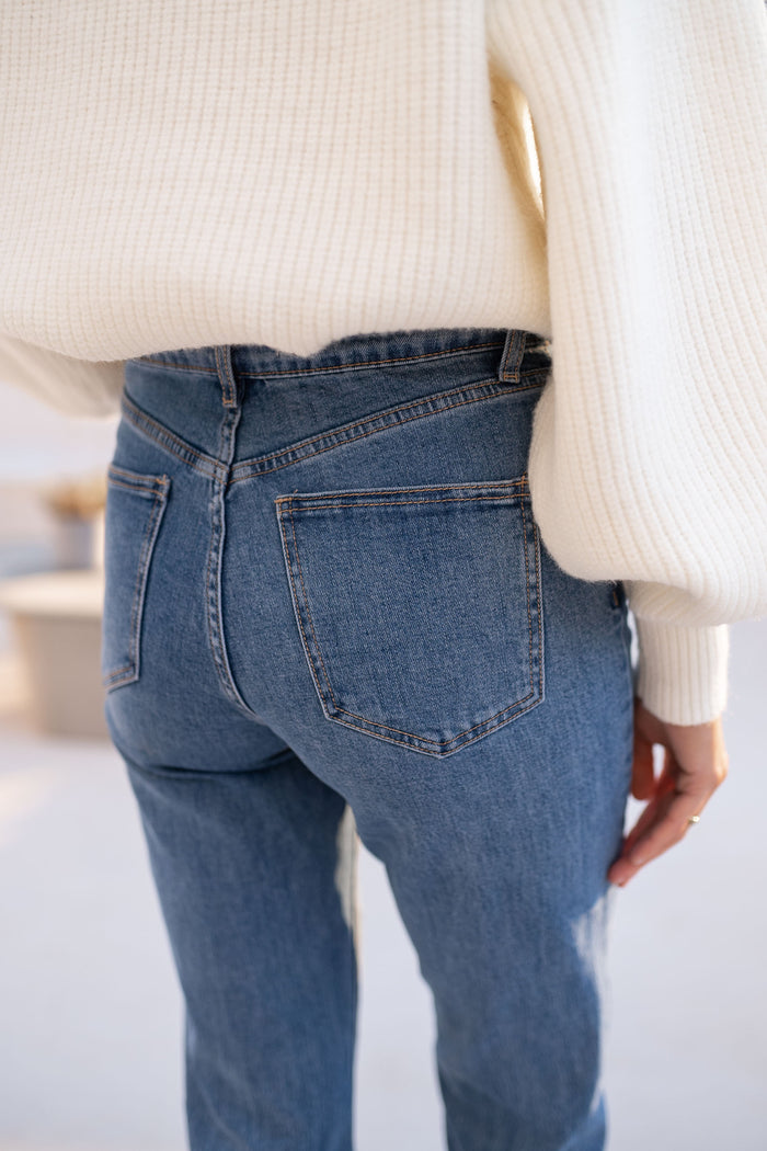Back view of medium-blue straight jeans showing pockets