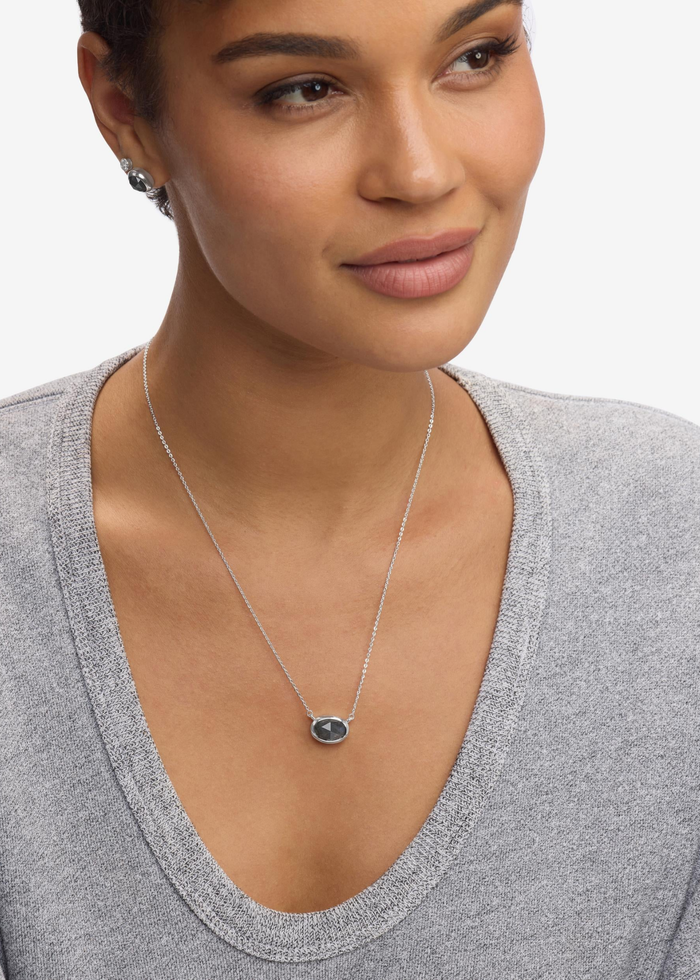 Woman wearing a silver framed labradorite pendant necklace