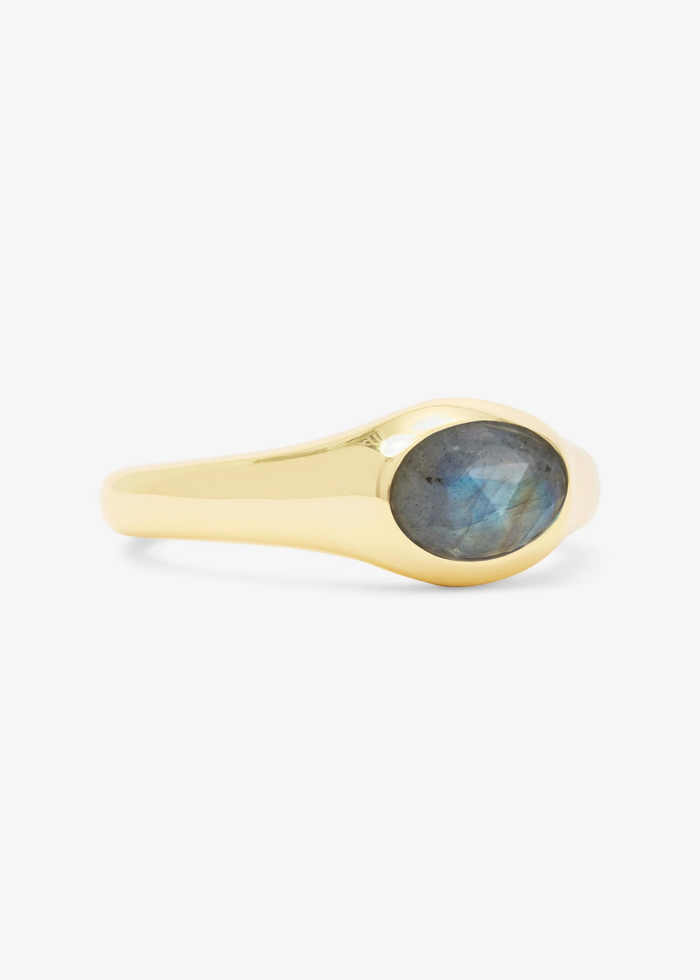 Gold signet ring with a labradorite stone on a white background and turned to the side