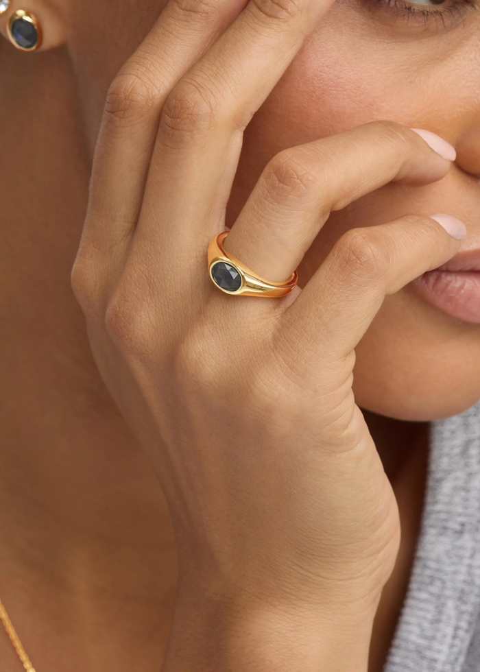 Woman wearing a gold signet ring with a labradorite stone