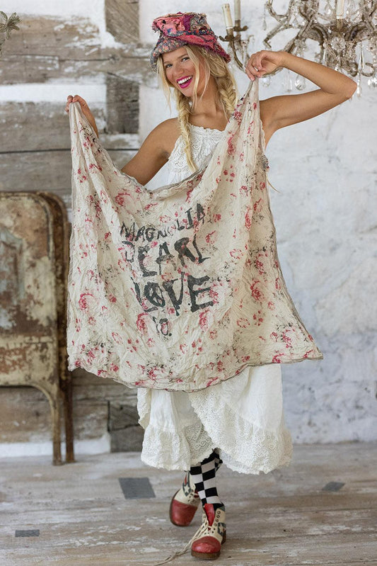 Woman in Magnolia Pearl artisan vintage dress, floral shawl, whimsical hat, eclectic style