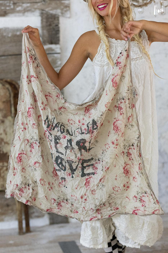 Woman in Magnolia Pearl artisan vintage dress holding whimsical floral shawl with handwritten text