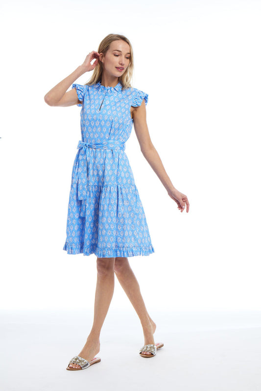 Model wearing the Patty Kim Megan Dress - Blue Foulards. a blue, knee length dress with a tie waist and flutter sleeves and collar.