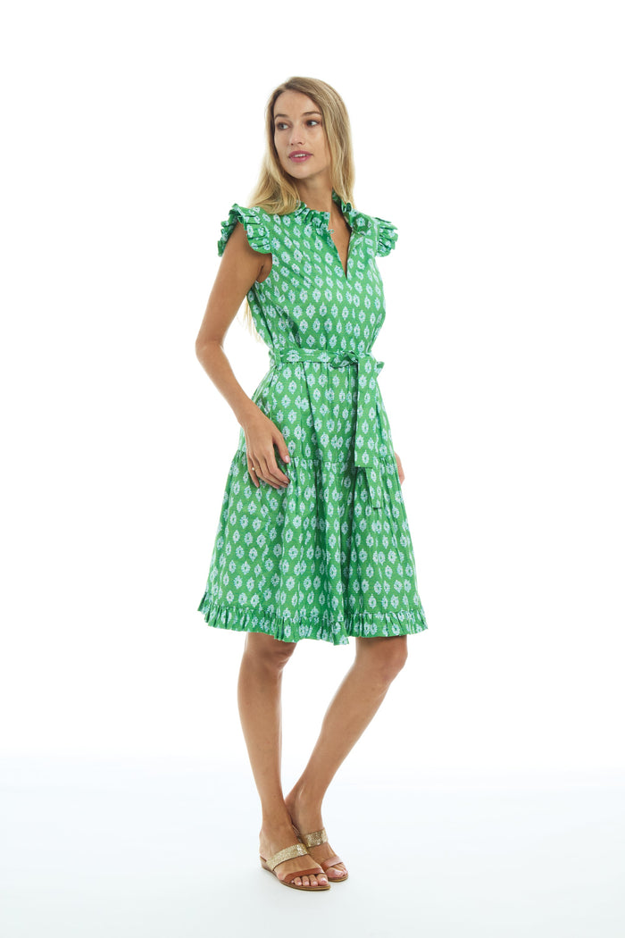 Model in the Patty Kim Megan Dress - Green Foulards. A knee length dress with flutter sleeves and ruffles on the collar and bottom hem, and a tie waist