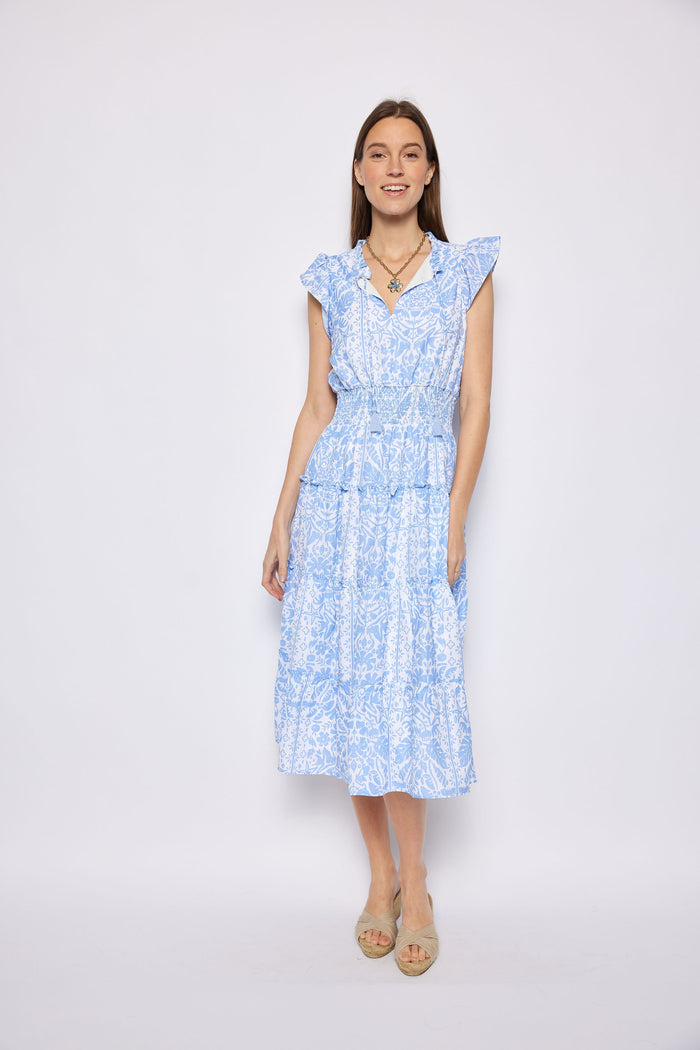 Woman wearing a light blue floral dress against a white background