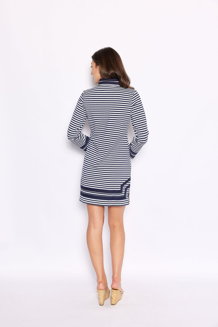 Back view of model  wearing a mini shift dress with navy and white stripes and navy piping around the collar, sleeve, and bottom hem
