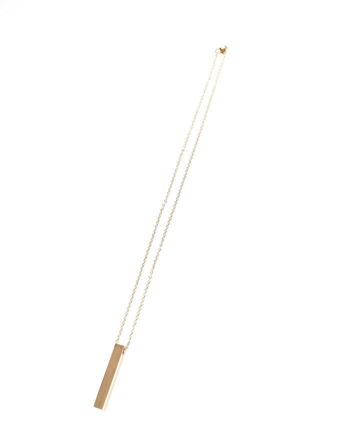 Martin Valen gold-color stainless steel column necklace with vertical bar pendant photographed top-down, fine chain and clasp visible