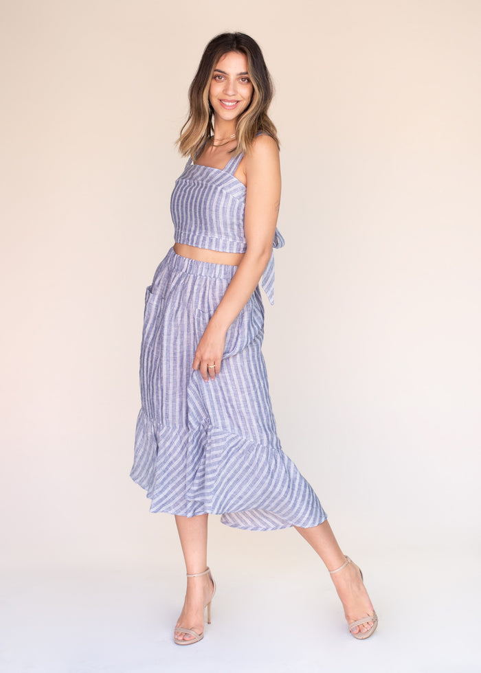 Woman wearing a blue striped outfit on a plain background