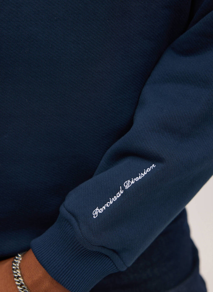 close up of the 'Percival Division' embroidery on the sleeve of the navy percival x ford sweatshirt