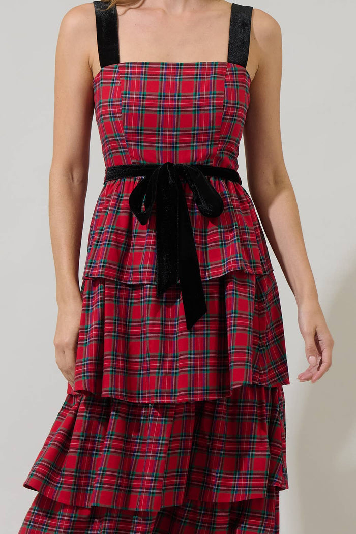 Red plaid dress with black straps and belt on a plain background