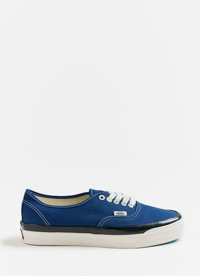 Side profile of the blue Vans Premium Authentic 44 shoes with white laces and a black sidewall, available at Percival.